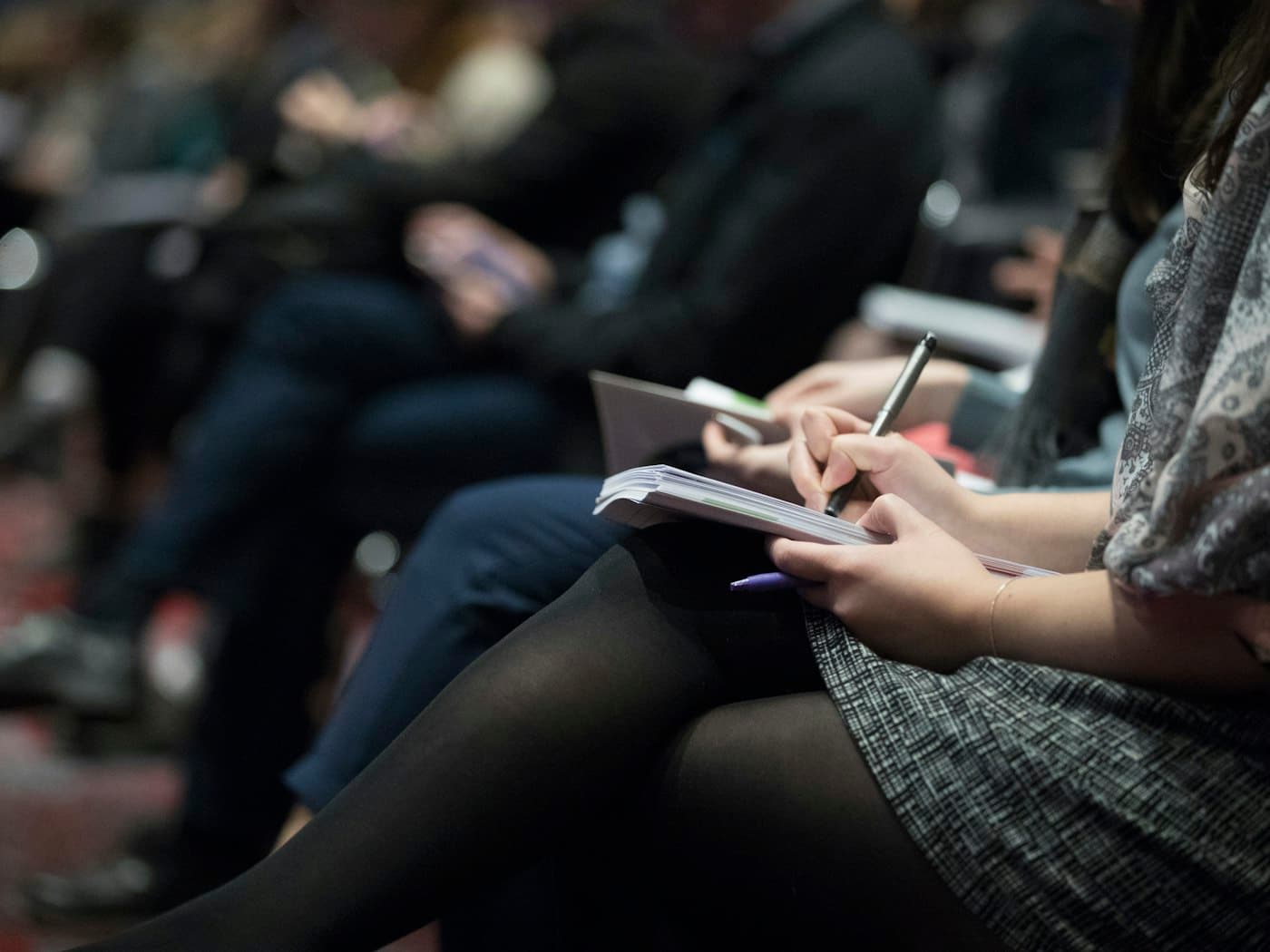 Students taking notes in a hall