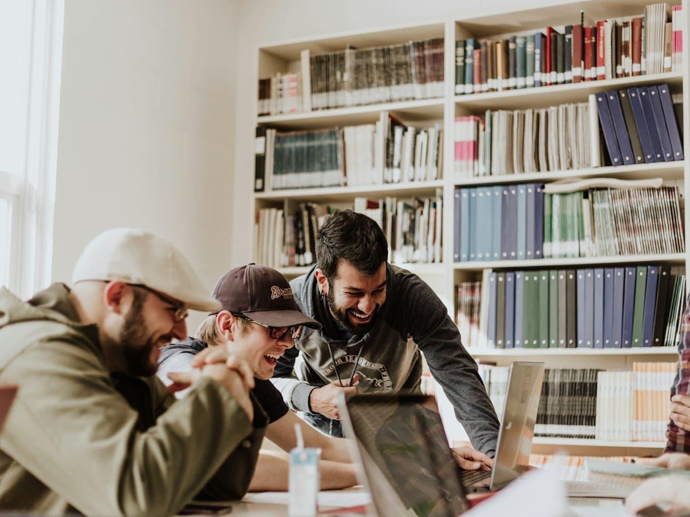 Students laughing together over a problem in the library